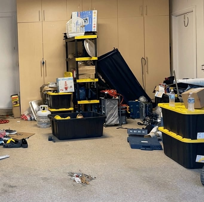 The same garage cleared to bare floor, with only the shelving and bins the homeowner chose to keep
