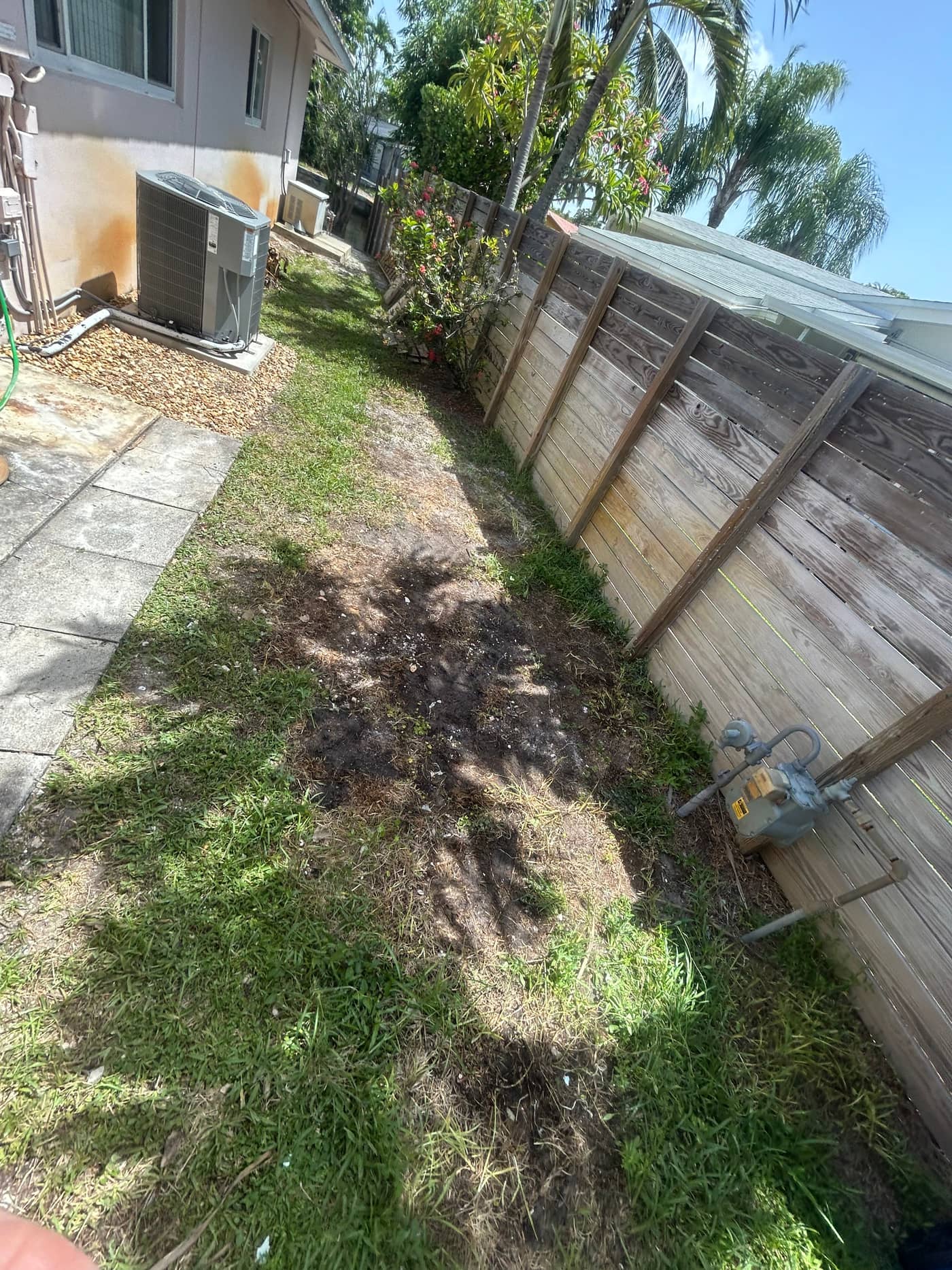 The same fence line with everything gone, showing a clear grass path back to the street