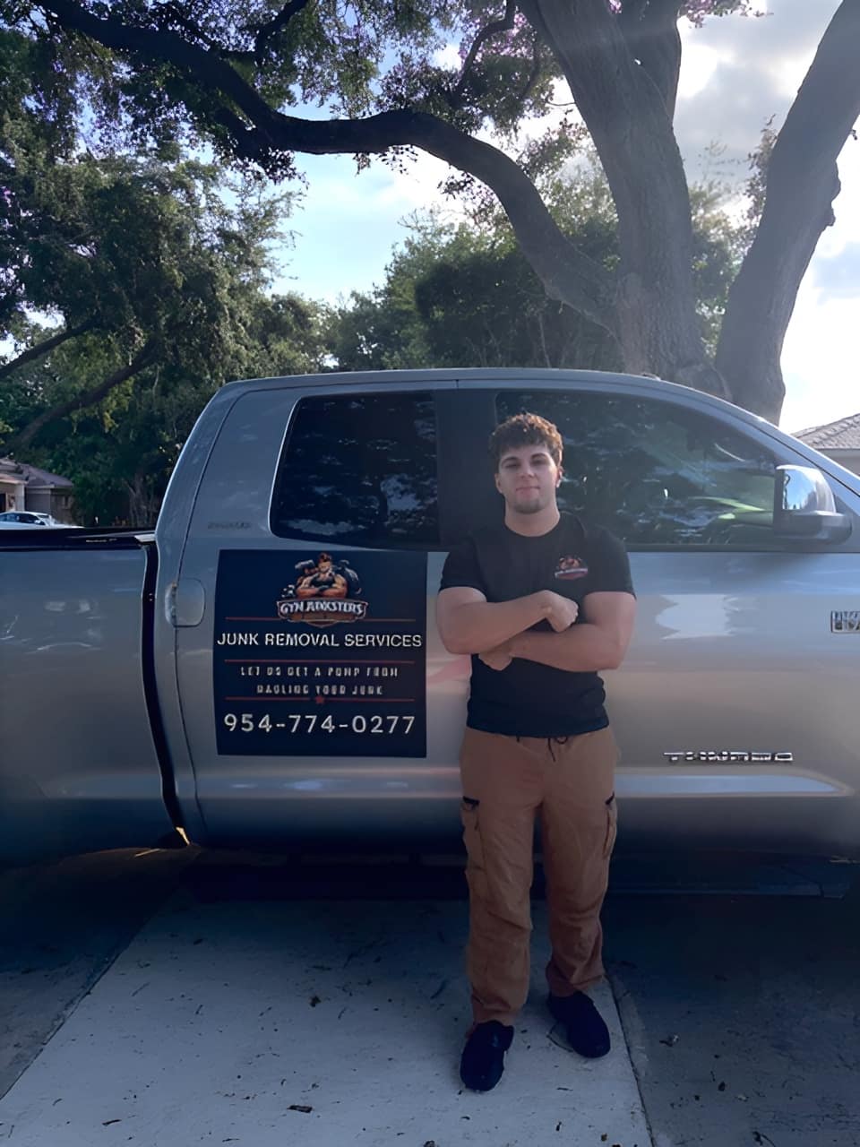 Johnny of Gym Junksters standing beside the Gym Junksters junk removal truck in South Florida